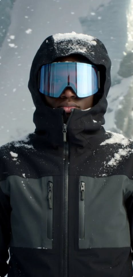 Мужчина в зимнем пейзаже с большими лыжными очками, крупный план