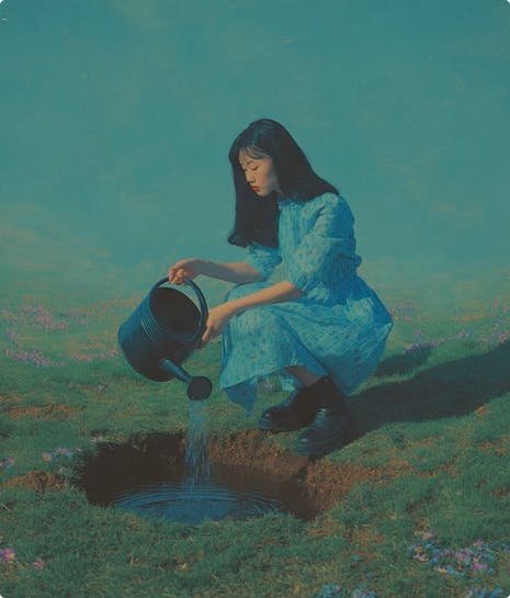 Женщина поливает маленький пруд с цветами из лейки